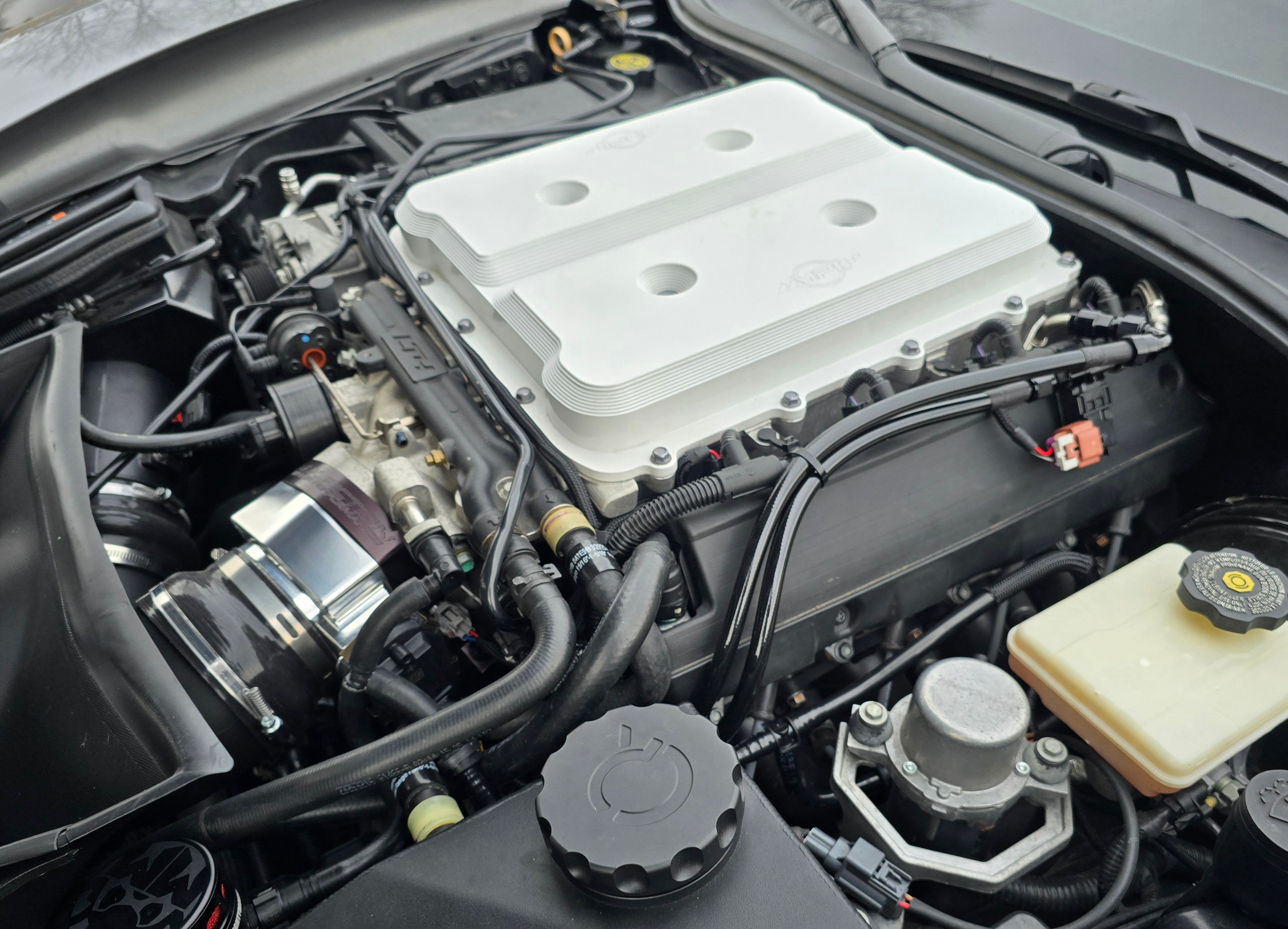 AuxJection LT4 auxiliary fuel injection system with black anodized plate installed on a Camaro ZL1, validated for 1130HP with zero external controllers.